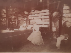Intérieur de la boutique avec Victor Perreyon, son épouse en cliente, sa vendeuse et son père, Pierre, vers 1900, 374II/23