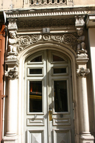 1 rue Ferrandière, porte d'entrée encadrée de bas-reliefs.