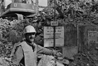 Ouvrier posant devant un chantier de démolition.